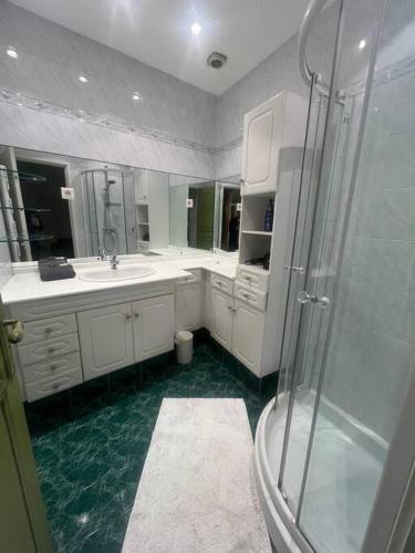 une salle de bain blanche avec une douche et un lavabo dans l'établissement Centrale - Grand T2 Bis proche de la mer, à Nice