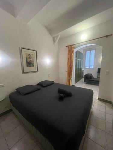 - une chambre avec un grand lit noir dans l'établissement Centrale - Grand T2 Bis proche de la mer, à Nice
