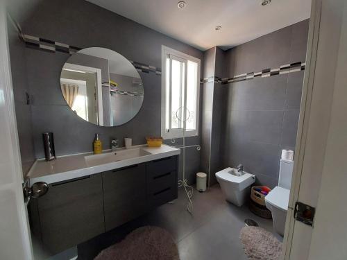 a bathroom with a sink and a mirror and a toilet at casa caravane in Benalmádena