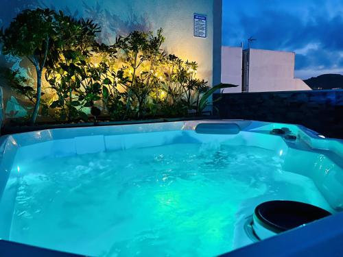 a jacuzzi tub in a backyard at night at Seaview Portside Penthouse SUPERIOR in St Paul's Bay