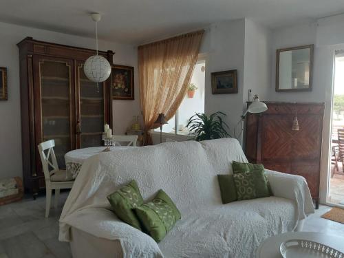 a living room with a couch with green pillows at casa caravane in Benalmádena