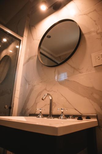 a bathroom sink with a large mirror on the wall at Catriel Suites in Catriel
