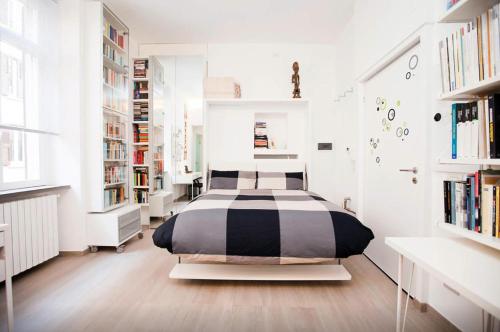 een slaapkamer met een bed in een kamer met boekenplanken bij Design Apartment - Milano City Center - Duomo in Milaan