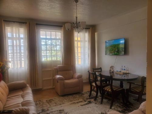 a living room with a couch and a table and chairs at Kiambu Heights Zone in Kiambu