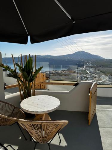 a table and chairs on a balcony with a view at CABO ESTE SUITES in Akrotiri