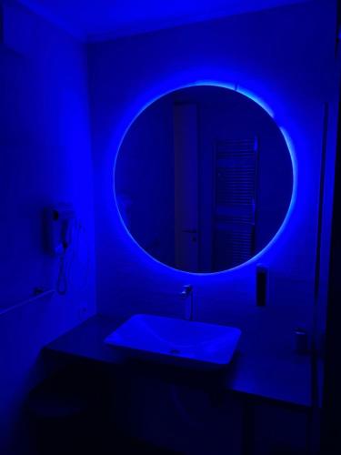 a blue room with a sink and a mirror at Apartman OMAR stan na dan besplatan parking Sarajevo in Sarajevo