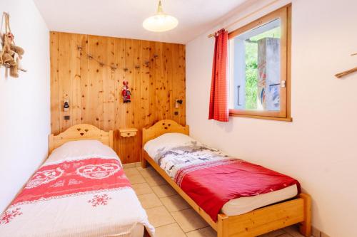 deux lits dans une chambre avec une fenêtre dans l'établissement Gentiane, à Valloire