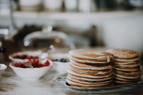 a stack of pancakes on a plate next to a bowl of strawberries at Villa Rucellai in Prato