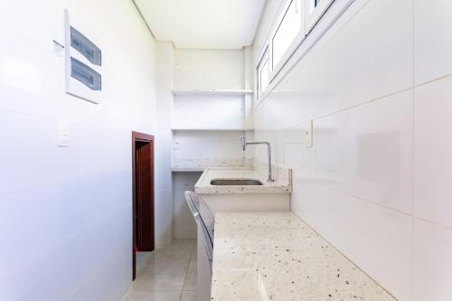 une salle de bain blanche avec un lavabo et une fenêtre dans l'établissement Bela Casa No Meridional-Serv de Limpeza-SH091, à Tamandaré