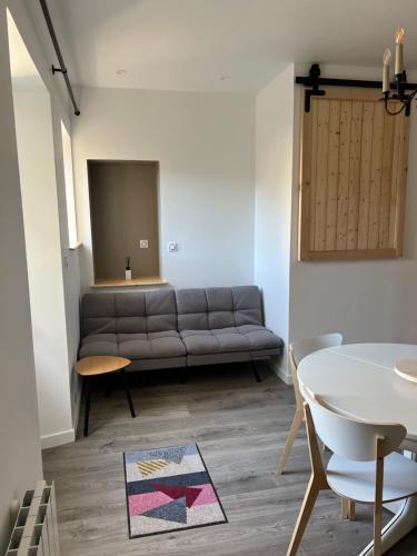 a living room with a couch and a table at Escapade en Baiocensis in Villiers-le-Sec