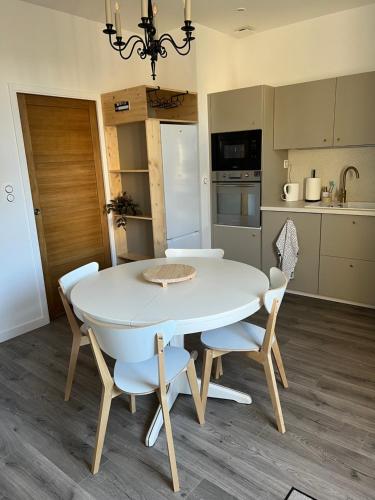 - une table à manger blanche et des chaises dans la cuisine dans l'établissement Escapade en Baiocensis, à Villiers-le-Sec