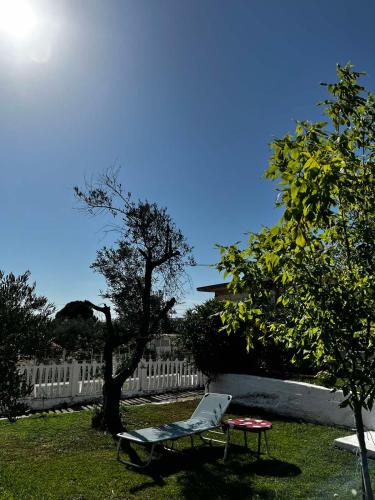 a chair and a table in a yard with a fence at Savvinio Country Apartment in Alexandroupoli