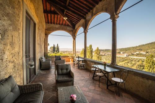 a patio with couches and tables and chairs on a building at Villa Rucellai in Prato