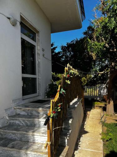 a fence with flowers on it in front of a house at Savvinio Country Apartment in Alexandroupoli