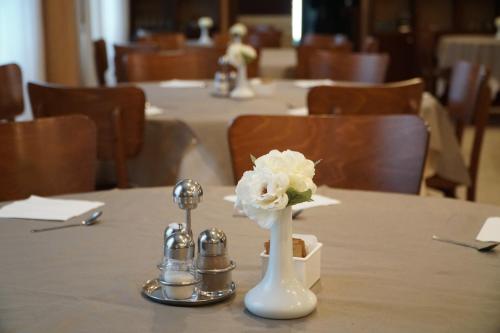 a white flower in a white vase on a table at Hotel President in Montecatini Terme
