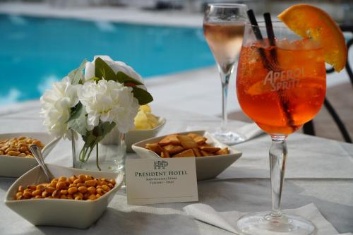 a table with two glasses and snacks and a drink at Hotel President in Montecatini Terme