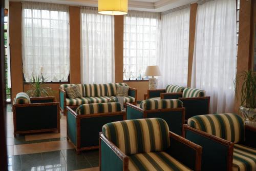 a waiting room with chairs and windows at Hotel President in Montecatini Terme