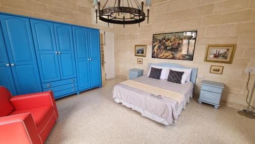 ein Schlafzimmer mit blauen Schränken und einem Bett und einem roten Sofa in der Unterkunft Grand Harbour View in Valletta