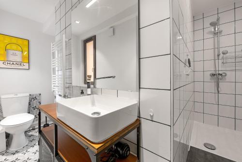 une salle de bain blanche avec un lavabo et des toilettes dans l'établissement Le Gorille hypercentre et climatisation, à Toulouse