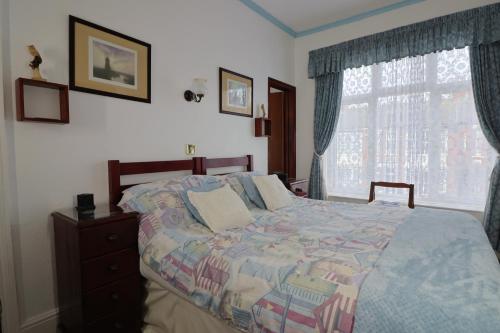 a bedroom with a bed and a window at Rosamaly Guesthouse in Hunstanton