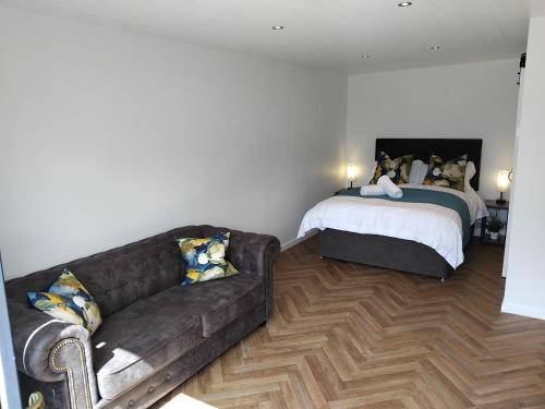 a living room with a couch and a bed at OAKWOOD GLAMPING Mourne Mountains in Moyad