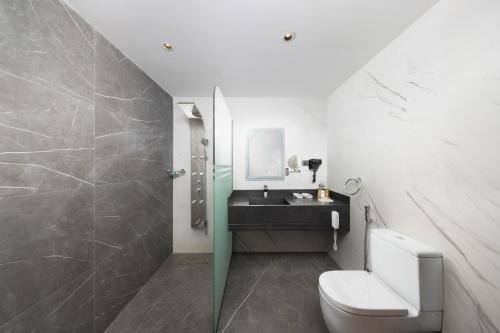 a bathroom with a sink and a toilet and a mirror at E Hotel in Al Madinah