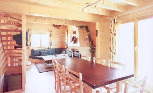 comedor y sala de estar con mesa y sillas en Chalet de 5 chambres avec jardin clos et wifi a La Bresse a 9 km des pistes, en La Bresse