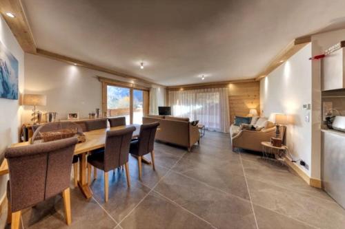 une salle à manger avec une table, des chaises et un canapé dans l'établissement MGM Charles Delys - 3 Rooms - Les Houches, aux Houches
