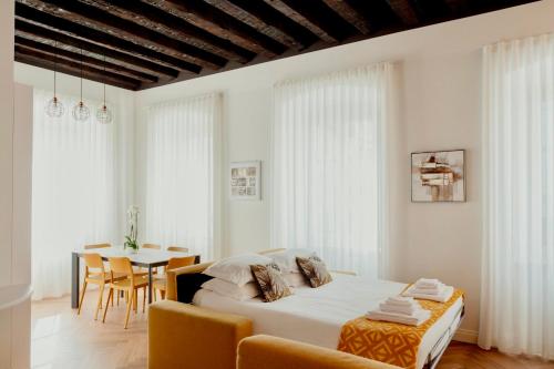 sypialnia z łóżkiem, stołem i krzesłami w obiekcie Casa Romano Suites w Trieście