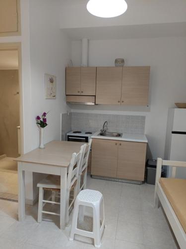 a kitchen with a table and a sink and a stove at Maria's Apartments in Kalyves