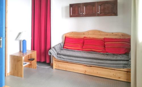 a bedroom with a bed with red pillows on it at Studio avec balcon a Vallandry in Landry