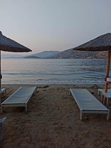 two beds on a beach with the water at Σπίτι σε μοναδική τοποθεσία in Líthion