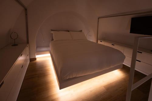 a bedroom with a white bed and a flat screen tv at Dimora della Vener Luxury Home in Vieste