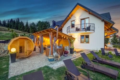 a house with a gazebo in the backyard at Apartamenty Polana Bradowiec in Tylicz