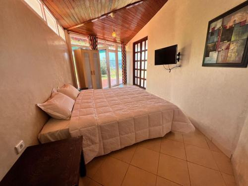 a bedroom with a bed and a television in it at Ocean Dunes House in Mirleft