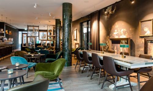 um restaurante com cadeiras e mesas e um bar em Motel One Amsterdam-Waterlooplein em Amesterdão