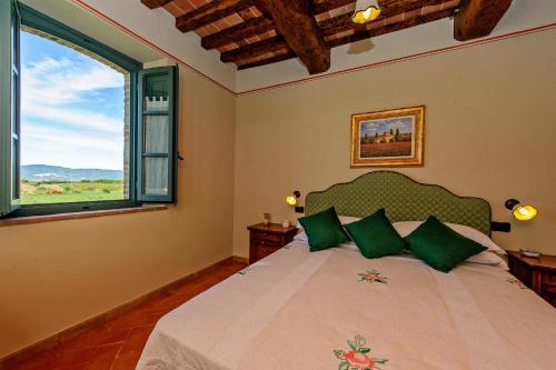 Un dormitorio con una cama con almohadas verdes y una ventana en Casa Vacanze La Fiorita, en Terontola