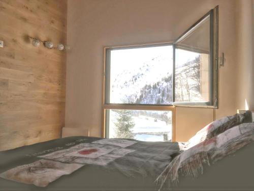 1 dormitorio con cama y ventana grande en Chalet de 6 chambres a Valmeinier a 500 m des pistes avec jardin amenage et wifi, en Valmeinier