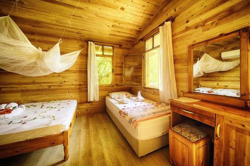 1 Schlafzimmer mit 2 Betten in einem Blockhaus in der Unterkunft Fullmoon Camp in Faralya