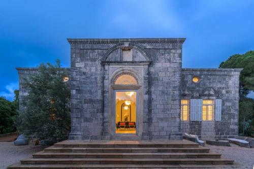 a large brick building with a door and stairs at Amani Luxury 4-Bedroom Villa & Pool in Batroun in Batroûn