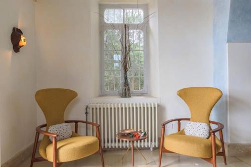 two chairs and a table in a room with a window at Amani Luxury 4-Bedroom Villa & Pool in Batroun in Batroûn