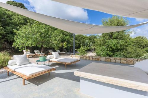 a patio with a white canopy and chairs and tables at Amani Luxury 4-Bedroom Villa & Pool in Batroun in Batroûn