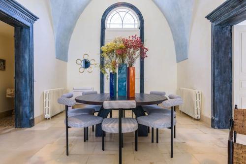 a dining room with a table with chairs and a vase with flowers at Amani Luxury 4-Bedroom Villa & Pool in Batroun in Batroûn