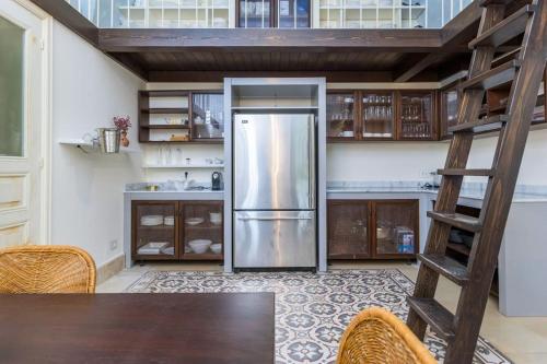 a kitchen with a stainless steel refrigerator and a ladder at Amani Luxury 4-Bedroom Villa & Pool in Batroun in Batroûn