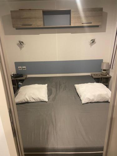 un lit dans une chambre avec deux oreillers dessus dans l'établissement Chez Dom et Sylvie, au Muy