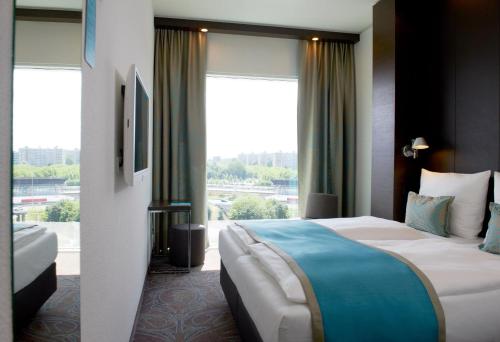 a hotel room with a bed and a large window at Motel One Amsterdam in Amsterdam