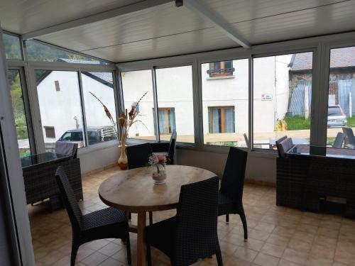 une salle à manger avec une table, des chaises et des fenêtres dans l'établissement Auberge La Prairie, à Matemale