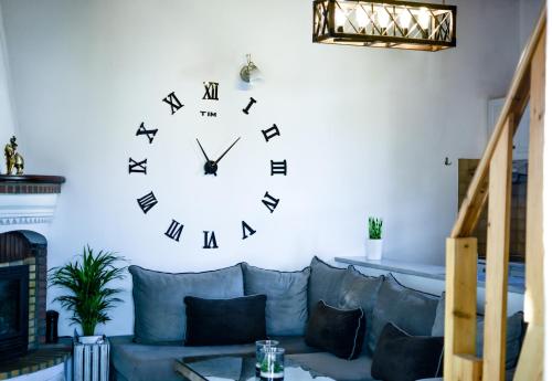 a large clock on a wall above a couch at Aura Skiathos in Skiathos Town