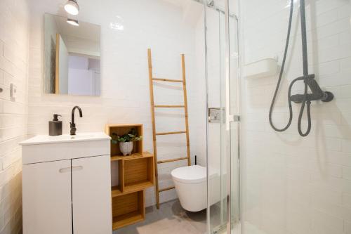 a bathroom with a shower and a toilet and a sink at Alba Beach Boutique Apartment in Estoril