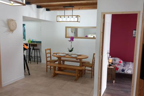 une salle à manger et une cuisine avec une table et des chaises dans l'établissement Gîte L'Instant Présent, à Messeix